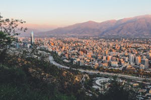 Breathtaking view of Santiago, Chile's skyline framed by mountains at sunset.